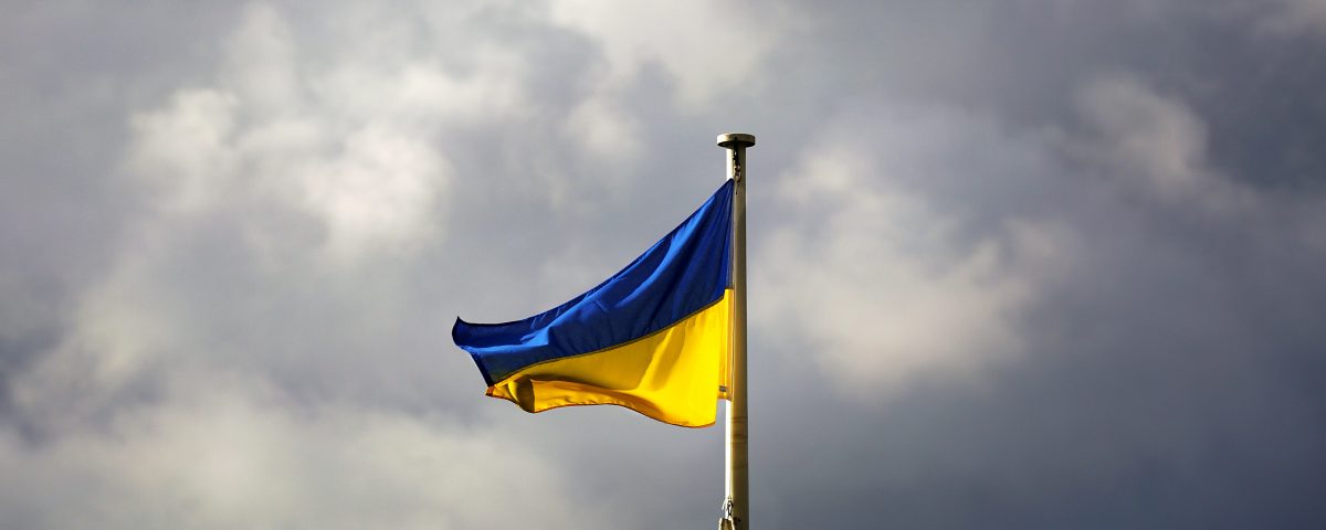 Flag of Ukraine flying against cloudy sky